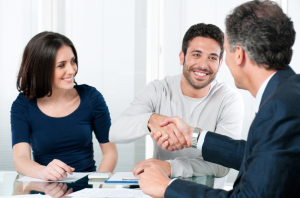 Happy couple seal a deal with their personal financial advisor at home